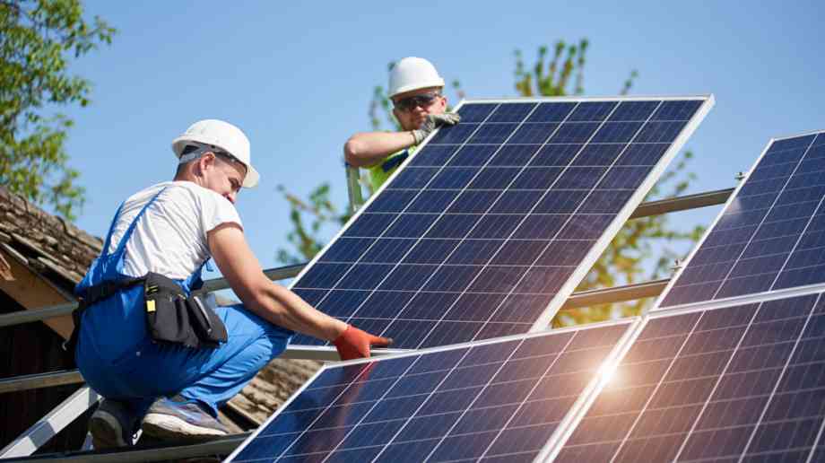 Construction workers installing solar panels
