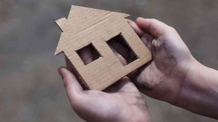 Child holding cardboard house